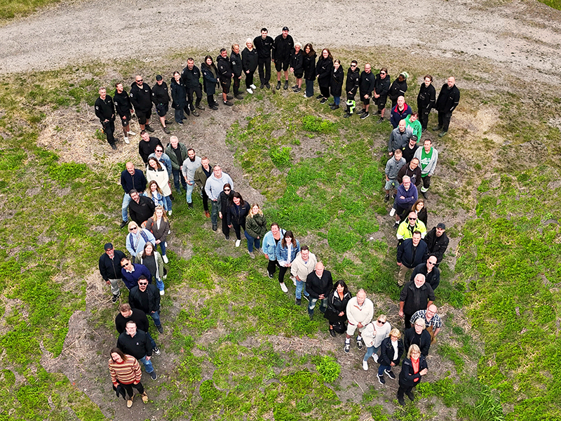 Bild på Nyköpingshems personal som formar ett stort N som i logotypen.