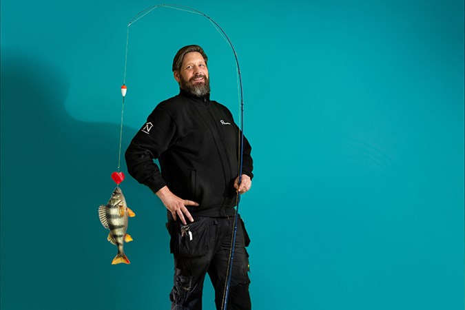 Tony Vargas Granström med fiskespö och fisk på kroken.