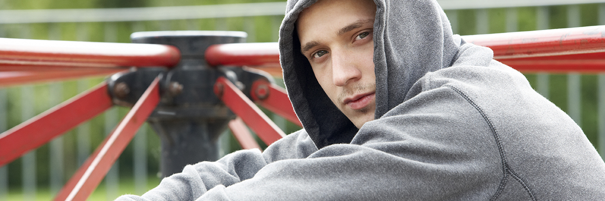 Kille som sitter i en park.