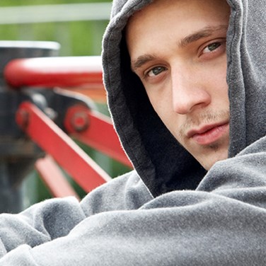 Kille som sitter i en park.