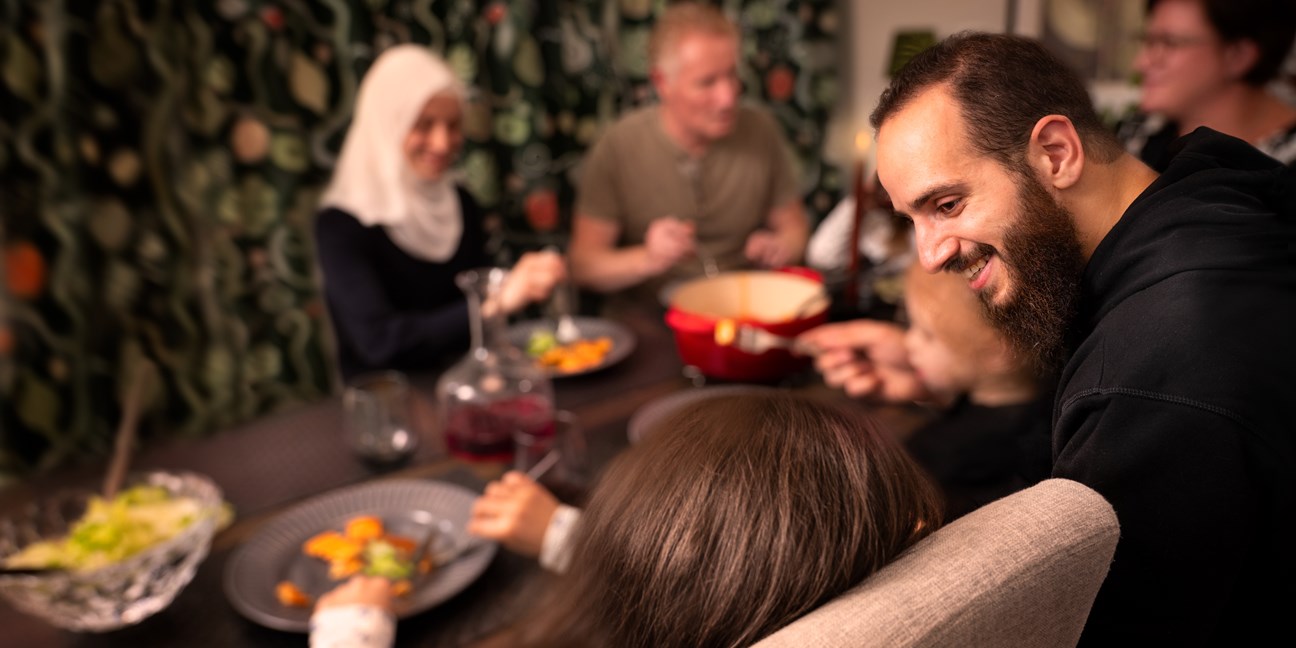 Familj och vänner samlade runt middagsbordet för en gemensam måltid.