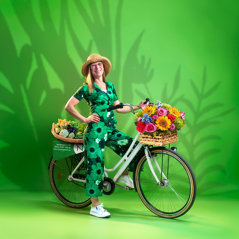 Grön bild på Marie Andersson med vit cykel.